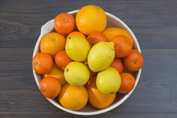 fruit bowl with different citrus fruits, oranges, tangerines and lemons