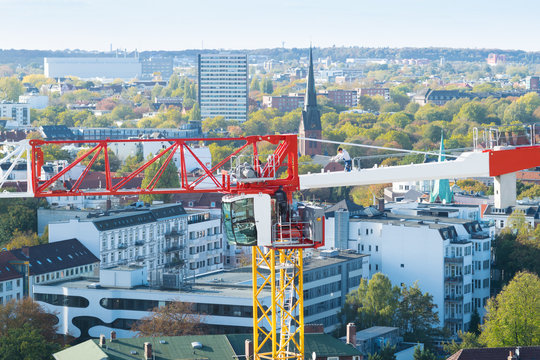 A builder on top of a tower crane above the city of Hamburg, Germany