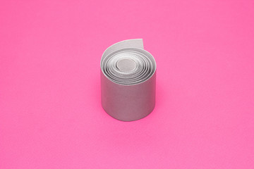 Silver tape to reflect light on a pink background, close-up, visibility on the road, safety, band