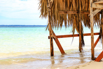Beach hut with palm roof on the beach. Paradise Island, Dominican Republic.