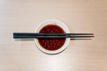 Sauce and chopsticks on wooden table