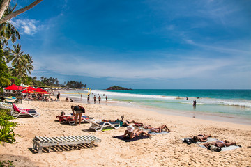 Obraz premium Tourists on the wonderful beach of Mirissa. Sri Lanka.