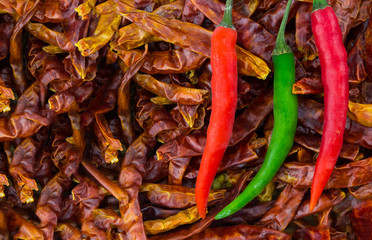 fresh hot chili pepper red green in the center on a background of dry pepper background spices thailand india base design menu copy space