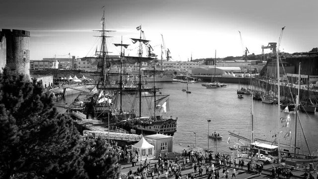 Brest, France - July 14, 2016: Brest's Maritime Festival showing old riggings of Etoile du Roy, La Fayette's ship Hermione and Cuauhtemoc in the harbor. Black and white timelapse - Penfeld river.