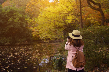 Woman tourist is enjoy traveling in the park during Autumn.