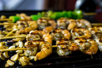 appetizing prawns seasoned fried with garlic on grill closeup background culinary design