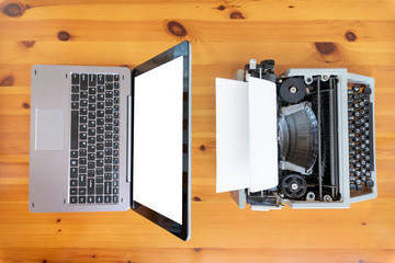 Old typewriter vs new laptop on the table. Concept of technology progress.