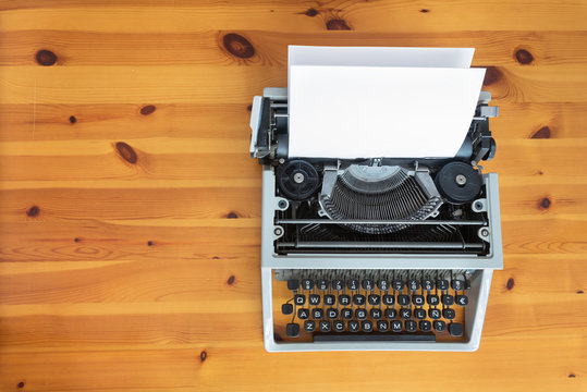 Old retro typewriter on wooden desk.