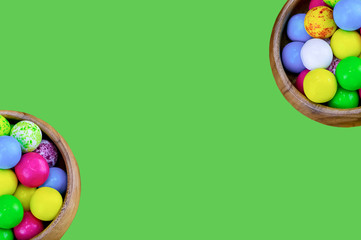 candy pink yellow multicolored lolly wooden bowl two symmetrical decoration design festive background on a green background