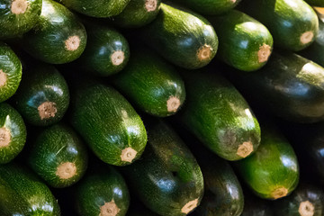 green zucchini horizontal long fruit stack of vegetables shiny skin background market tray