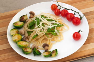 spaghetti with caramelized vegetables on a white plate
