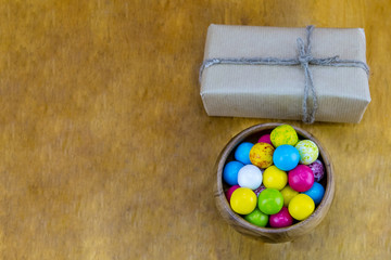 festive box rustic style kraft paper with natural rope up wooden bowl round with colorful candy on a wooden background festive design