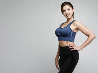 sport and people concept: Cheerful attractive young fitness woman in top and black leggings