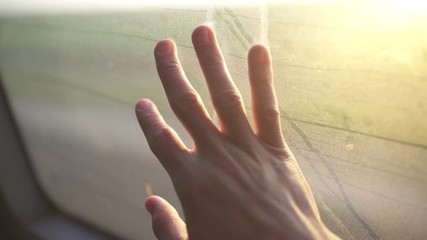 Hand rests on a bus window during a ride