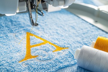 Embroidery machine and alphabet design on towel in hoop