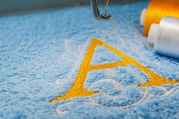 Alphabet design on towel in hoop of embroidry machine