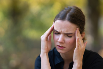 Young woman with headache, pain, or worries
