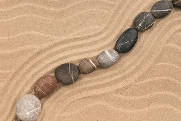 Fototapeta na wymiar Zigzag made of stones among sand dunes.