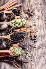 Different types of whole Indian spices in wooden background close-up.