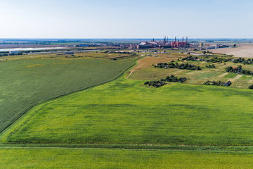 European plain landscape, view from a great height. In the distance are visible factories