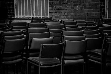 Fototapeta premium Chairs Stacked In A Dark Alleyway For Storage