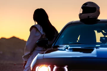 Foto op Plexiglas Een vrouwelijke autocoureur die naar de zonsopgang kijkt voordat hij de baan op gaat © SIX60SIX