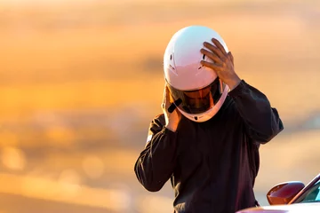 Rolgordijnen Een coureur op een raceschool die zijn helm opdoet voordat hij zijn auto op het circuit zet. © SIX60SIX