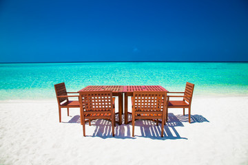 Table and chairs on tropical amazing vibrant beach in Maldives.