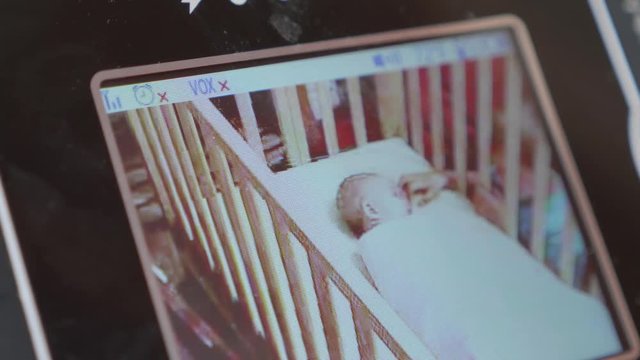 Dolly Shot Of Baby Monitor With Newborn Girl In Her Crib And Brother