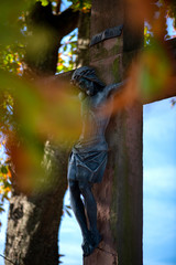 Fototapeta na wymiar Allerheiligen und Allerseelen, Symbolbild alte Christusfigur am Kreuz, an einem Herbstag
