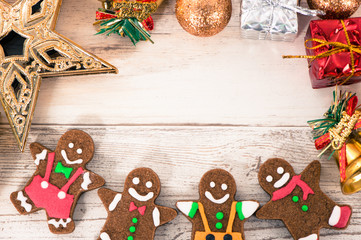 Beautiful Christmas composition and decoration with baked gingerbread man cookie on light wooden background, flat lay, top view, copy space (text space)