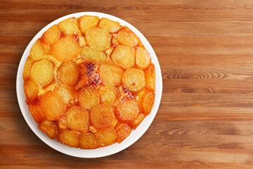Homemade apple upside down cake on wooden table.