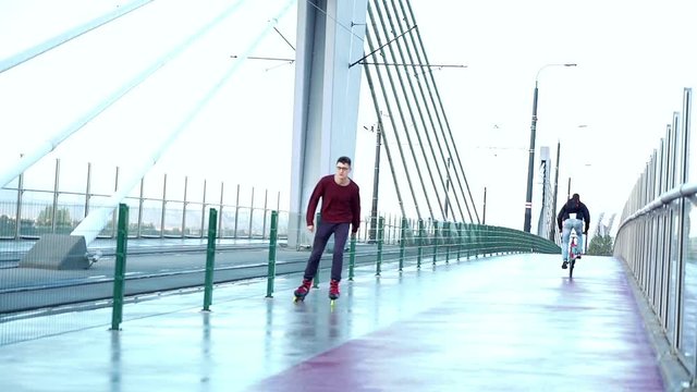 Young man in rollerblades riding in the city, super slow motion 
