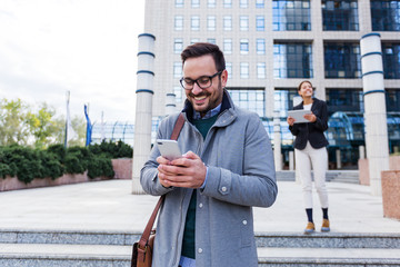 Business man receiving a happy message on his smartphone