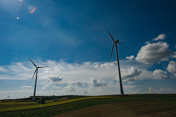 Energy and ecology power production with clean energy. Wind turbines and agricultural fields on a summer day.