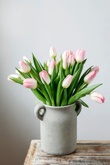 Bouquet of pink tulips in grey ceramic vase.