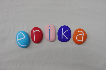 Erika, feminine given name with colored stones over white sand