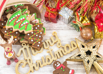 Beautiful Christmas composition and decoration with baked Christmas gingerbread cookie in paper bag on light wooden background, flat lay, top view, copy space (text space)