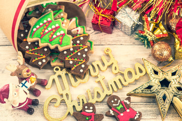 Fototapeta na wymiar Beautiful Christmas composition and decoration with baked Christmas gingerbread cookie in paper bag on light wooden background, flat lay, top view, copy space (text space)
