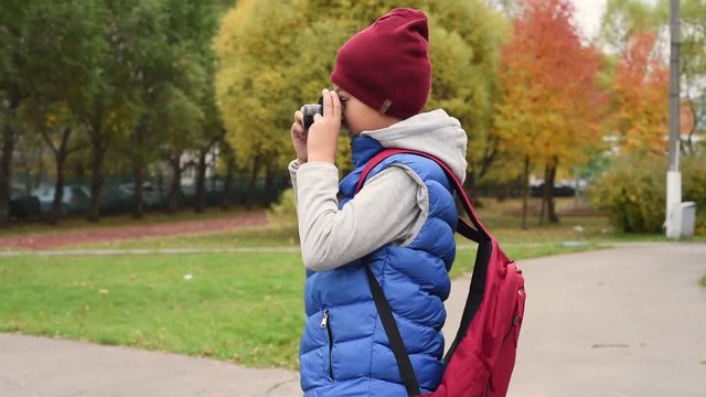 Camera boy. Handsome and cute mixed boy with photo camera. Children are bloggers. Boy making picture of you. 