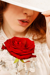Woman in victorian clothing holding big red rose.