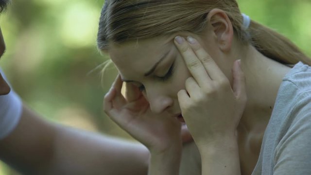 Man staying near girl feeling strong headache, kind not indifferent passer-by