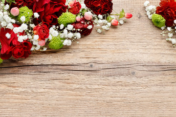 Floral arrangement with orchids, roses and carnations on wooden background