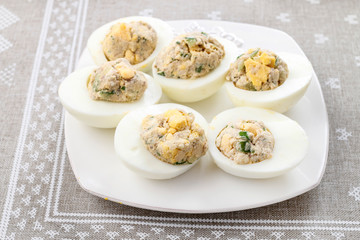 Stuffed easter eggs on white plate.