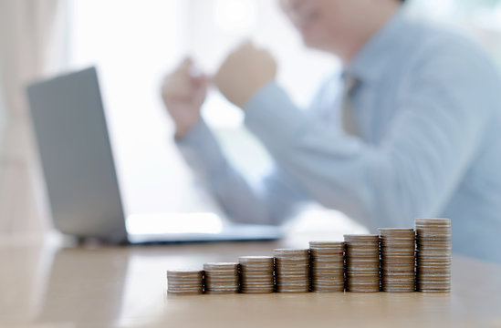 Businessman with working at workplace. coins stack