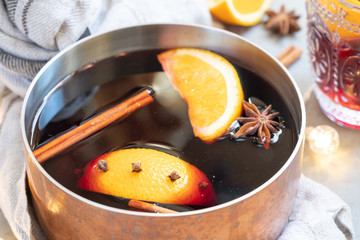 Mulled wine hot drink with oranges and spices in copper pot