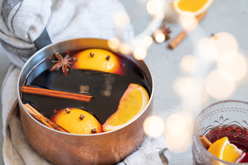 Mulled wine hot drink with oranges and spices in copper pot