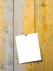 Blank square instant photo frame on yellow weathered wooden boards background