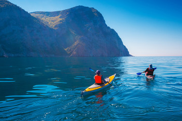 Kayaking. People swim in the sea kayak near the mountains. Adventures on the water