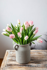 Bouquet of pink tulips in grey ceramic vase.